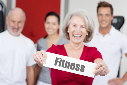 Senior Woman Holding Fitness Sign With Family In Background