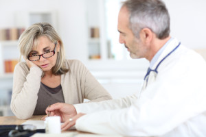 Doctor giving medicine to senior woman for arthritis pain