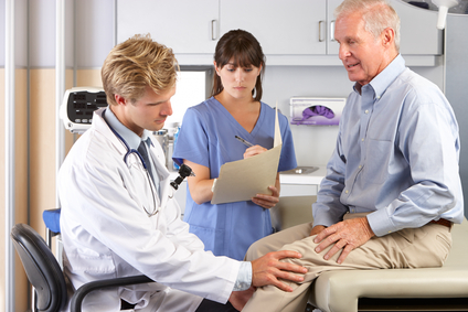 Doctor Examining Male Patient With Knee Pain