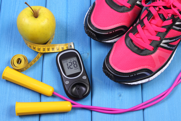 Glucometer, sport shoes, fresh apple and accessories for fitness