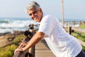 healthy middle aged man workout at the beach in the morning, strength, stretch