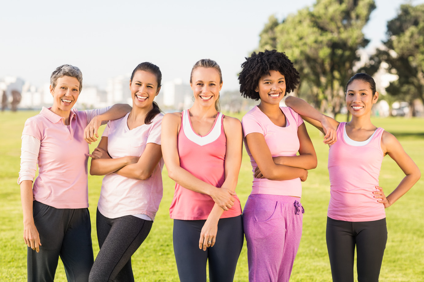 Portrait of smiling women wearing pink for breast cancer in parkland