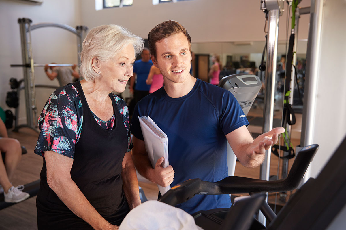 trainer-with-senior-woman-at-treadmill
