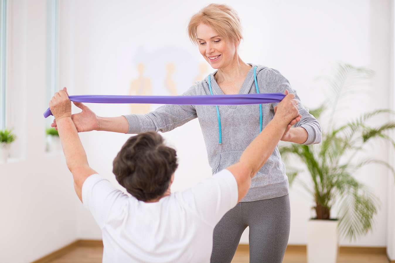 trainer-resistance-band-senior-woman-client