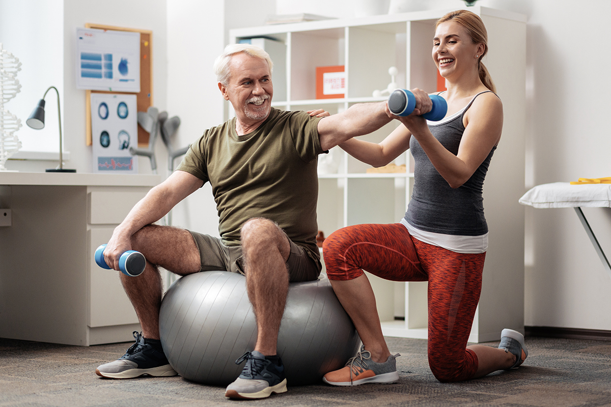 female-trainer-senior-client-exercise-ball